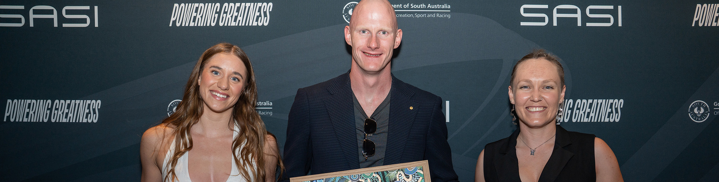 Brittany Castelluzzo, Rowan Crothers and Anu Francis holding their Aboriginal artwork awards