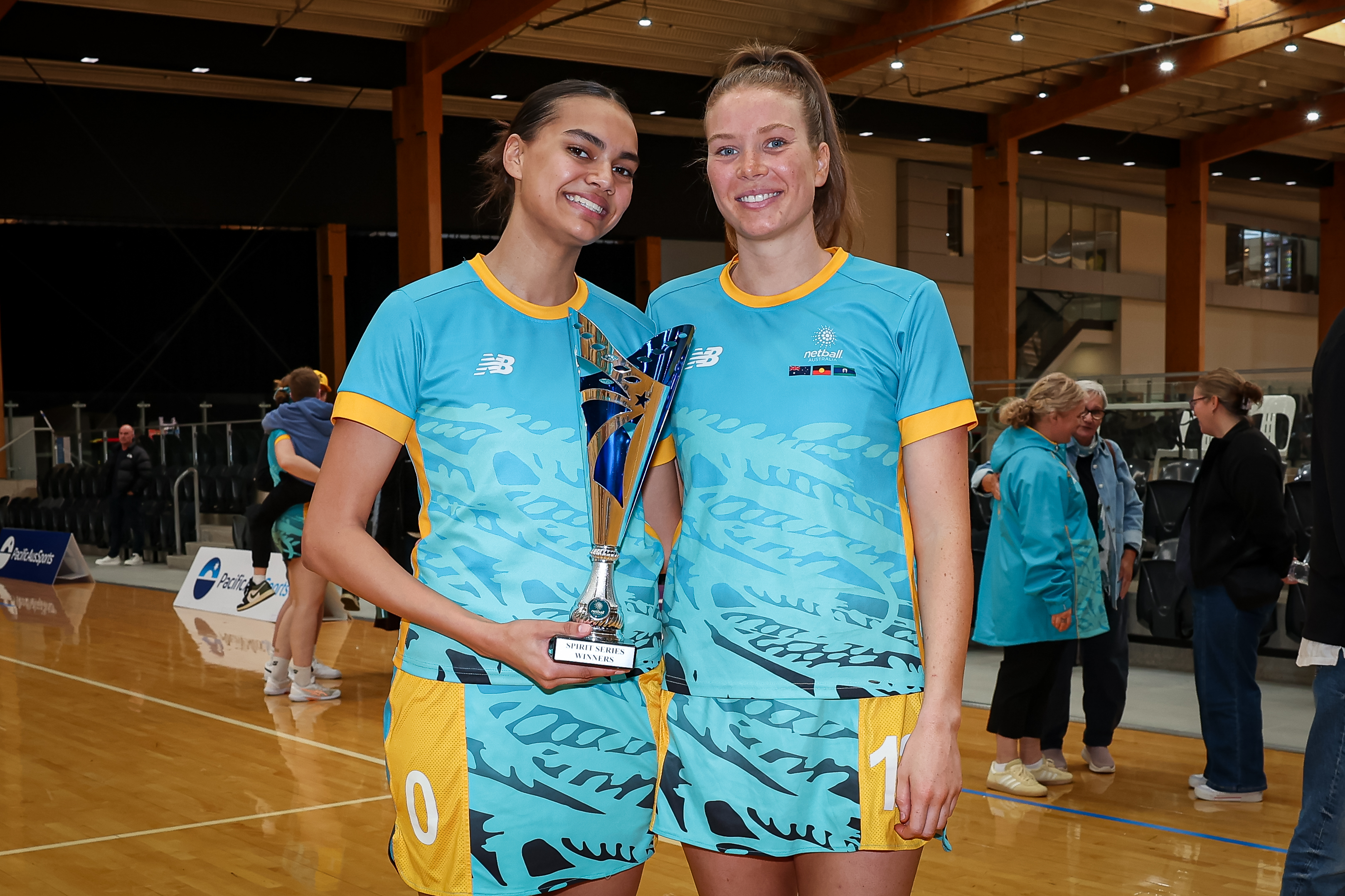 Darcy May-Martin two netballers holding trophy