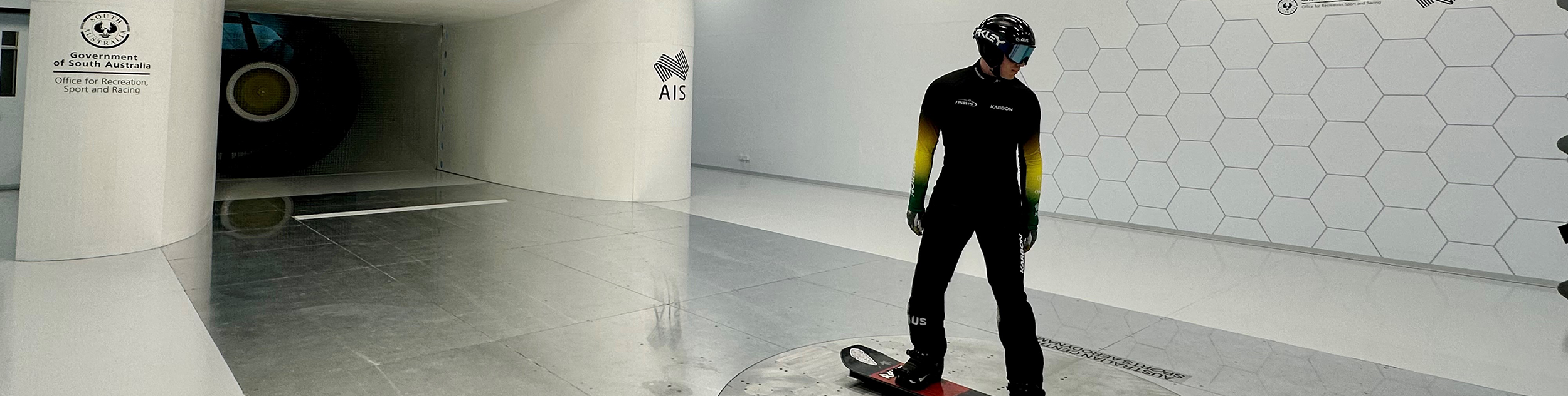 A snowboarder standing in front of the wind tunnel