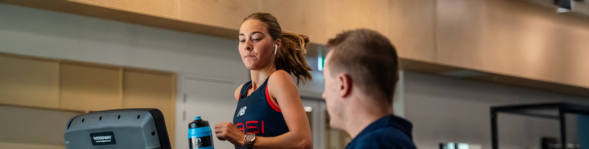 Olivia Sandery walking on a treadmill with Jared Tallent watching on
