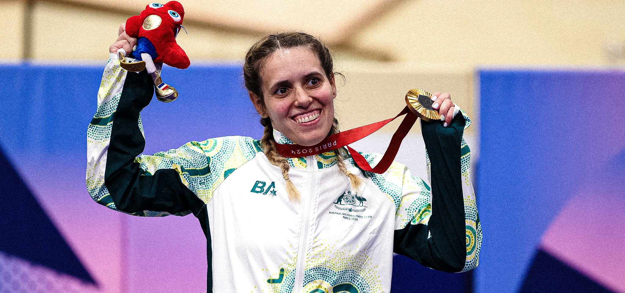 Amanda Reid smiling while holding her gold medal